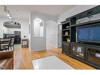 Bright living room with hardwood floors, built-in shelving, and kitchen view at 1850 Cotillion Dr # 3215, Atlanta, GA 30338