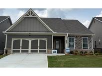 Charming single-Gathering home featuring a two-car garage, stone accents, and a well-manicured lawn at 615 Moorhen Way, Loganville, GA 30052
