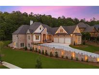 Stunning brick home featuring a three-car garage, manicured lawn, and elegant landscaping with privacy wall at 11 Brownson Ct, Acworth, GA 30101