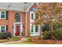 Brick home with two-car garage, red door and landscaping at 5073 Verbena Nw Dr, Acworth, GA 30102