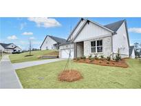 Charming home with a well-manicured lawn, beautiful landscaping, and a classic gray brick exterior at 229 Mooney Rd, Woodstock, GA 30188