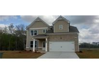 Two-story home featuring a two-car garage, neutral siding, and welcoming front entry at 6060 Spring Way, Stonecrest, GA 30038