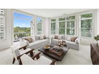 Bright living room with large windows, hardwood floors, and comfortable seating area at 2500 Peachtree Nw Rd # 405S, Atlanta, GA 30305