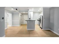 Spacious living room with hardwood floors leading to a modern kitchen featuring stainless steel appliances at 2700 Pine Tree Ne Rd # 1007, Atlanta, GA 30324