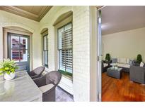 Inviting front porch with seating area and view into a cozy sunroom with hardwood floors at 3127 Lenox Road # 6, Atlanta, GA 30324