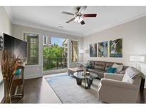 Bright living room featuring a leather sectional, ceiling fan, and access to the balcony at 3621 Vinings Slope Se # 3411, Atlanta, GA 30339