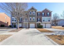 Three-story townhouses with attached garages and well-maintained landscaping at 1294 Park Pass Way, Suwanee, GA 30024