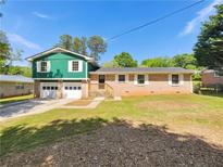 Charming two-story home featuring a well-maintained front yard and an attached two-car garage at 211 Murphy Ave, Lawrenceville, GA 30044