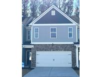 Two-story townhome with gray siding, brick accents, and a two-car garage at 133 Stanchion Dr, Union City, GA 30291