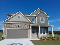 Charming two-story home featuring stone accents, neutral tones, and a well-manicured lawn at 5994 Spring Way, Stonecrest, GA 30038