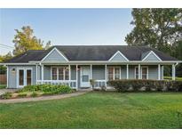 Gray Ranch house with front porch, landscaping, and a large yard at 79 Russell Ln, Dallas, GA 30157