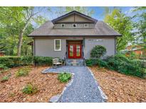 Craftsman style home with red door, gravel path, and manicured landscaping at 4599 Park Dr, Pine Lake, GA 30083