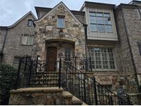 Charming multi-story brick home featuring stone accents and an iron-railed entrance staircase at 4853 Stonehall Pl, Atlanta, GA 30339