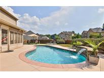 Backyard features a beautiful in-ground pool with a waterfall feature and ample seating at 4360 Carver Ct, Cumming, GA 30040