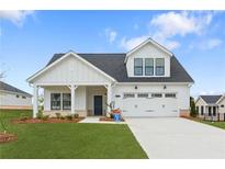 Charming two-story home featuring a covered porch and a two-car garage in a suburban setting at 5225 Maggie Mae Ln, Cumming, GA 30028