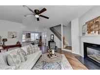 Bright living room featuring hardwood floors, fireplace, modern furniture, and open floor plan to kitchen at 3676 Chattahoochee Summit Dr, Atlanta, GA 30339
