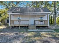 Charming white cottage with a front porch and landscaped yard at 5361 N Main St, Acworth, GA 30101