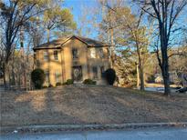 Two-story house with tan siding, dark brown door, and landscaping at 7592 Watson Kaye, Stone Mountain, GA 30087