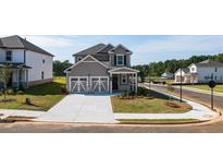 Charming two-story home with a two car garage, covered entry, and well-manicured lawn and landscaping at 1857 Holmsey Cir, Conyers, GA 30094