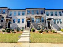Brick townhome with front steps, landscaping, and a modern design at 4326 Water Elm Aly, Doraville, GA 30360