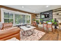 Inviting living room with a stone fireplace, large windows, and a stylish marble-topped coffee table at 2953 Collier Nw Dr, Atlanta, GA 30318