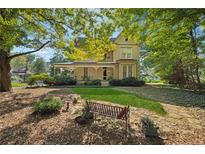 Charming two-story home with a covered front porch and well-manicured lawn surrounded by mature trees at 4671 Collins Ave, Acworth, GA 30101