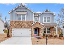 Charming two-story home with brick and blue siding, white garage, and a well-manicured front yard at 5070 Trescott Path, Cumming, GA 30028