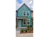 Charming two-story townhome with a colorful exterior, inviting front porch, and well-manicured landscaping at 1095 Tucker Ave # 203, Atlanta, GA 30310