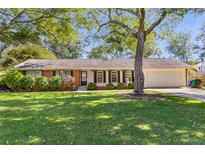 Charming brick ranch with an attached garage, mature trees, and a well-manicured lawn at 3113 Octavia Pl, Atlanta, GA 30340