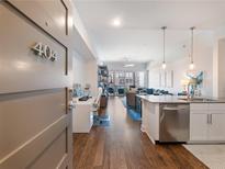 Bright open-concept living space boasts a modern kitchen and dining area with hardwood floors at 1100 Howell Mill Rd # 404, Atlanta, GA 30318