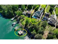 An aerial view showcases the expansive waterfront property with a pool and private dock at 6308 Woodlake Dr, Buford, GA 30518