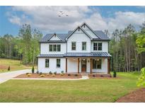 Beautiful two-story home with white siding, dark roof, covered porch, and a well-manicured lawn at 1709 Eastside Parc St, Atlanta, GA 30316
