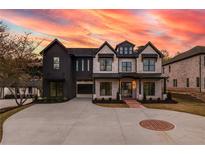 Beautiful two-story home featuring a black and white exterior, complemented by an expansive driveway and manicured landscaping at 159 Shadburn Ferry Rd, Buford, GA 30518