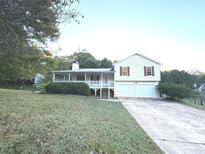Charming home featuring a covered porch, two-car garage, and well-maintained landscaping at 413 Kenny Ln, Temple, GA 30179
