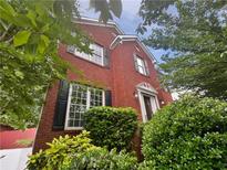 Charming brick home featuring black shutters, surrounded by lush greenery and mature trees at 200 Eagle Glen Ct, Woodstock, GA 30189