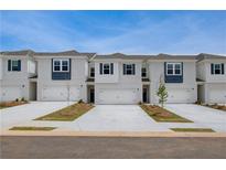Charming townhomes featuring brick, white siding, garages, and well-manicured landscaping at 212 Sanctuary Drive, Mcdonough, GA 30253