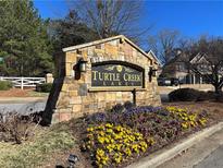 Stone Turtle Creek Lakes sign surrounded by colorful flowers at the entrance to a residential community at 1425 Turtle Dove Ln, Lawrenceville, GA 30043