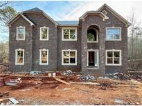 New two-story brick home features a classic design with large windows and an arched entryway at 5410 Deer Run Dr, Conyers, GA 30094