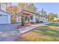 Modern home showcasing a lovely front yard, covered entry, and a matching detached garage at 49 Allison Dr, Dallas, GA 30157