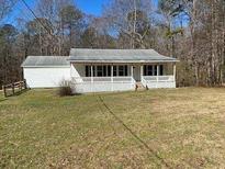 Quaint single-story home featuring a welcoming front porch and light-colored siding at 4965 Cochran Mill Rd, Chattahoochee Hills, GA 30213