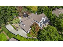 Aerial view of the luxury home featuring a large backyard, a spacious driveway, and mature landscaping at 980 Fenimore Cir, Sandy Springs, GA 30350