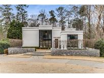 Stunning contemporary home featuring unique architecture and professional landscaping for sophisticated curb appeal at 3184 Wood Valley Nw Rd, Atlanta, GA 30327
