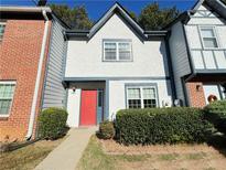 Charming townhome with a stucco facade, tidy landscaping, and a vibrant red front door at 3589 Main Station Sw Dr, Marietta, GA 30008