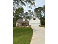 Charming home featuring a manicured lawn, a two car garage and decorative window shutters at 90 Hammock Dr, Covington, GA 30016