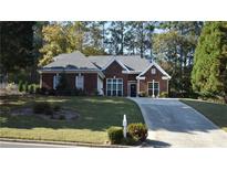 Brick ranch house with landscaped yard and long driveway at 1025 Copper Creek Dr, Canton, GA 30114