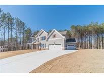 Two-story house with gray siding, three-car garage, and a large driveway at 268 Pinewood Dr, Covington, GA 30014