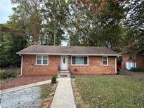 Brick ranch house with a landscaped lawn and walkway at 2059 Clearwater Se Dr, Marietta, GA 30067