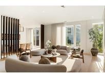 Bright living room with floor to ceiling windows, modern furniture, and neutral color palette at 1301 Peachtree St # 4L, Atlanta, GA 30309