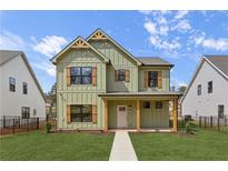 Charming two-story home featuring a well-manicured lawn, complemented by board and batten siding and detailed window shutters at 38 Puckett Se Rd, Emerson, GA 30137