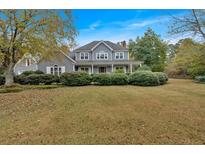 Charming gray two-story home with a welcoming front porch and lush, landscaped front yard at 36 Latimer Nw Ln, Cartersville, GA 30121